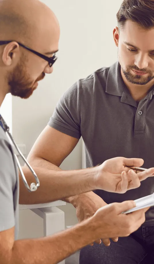 Chiropractor explaining treatment details to patient using a paper