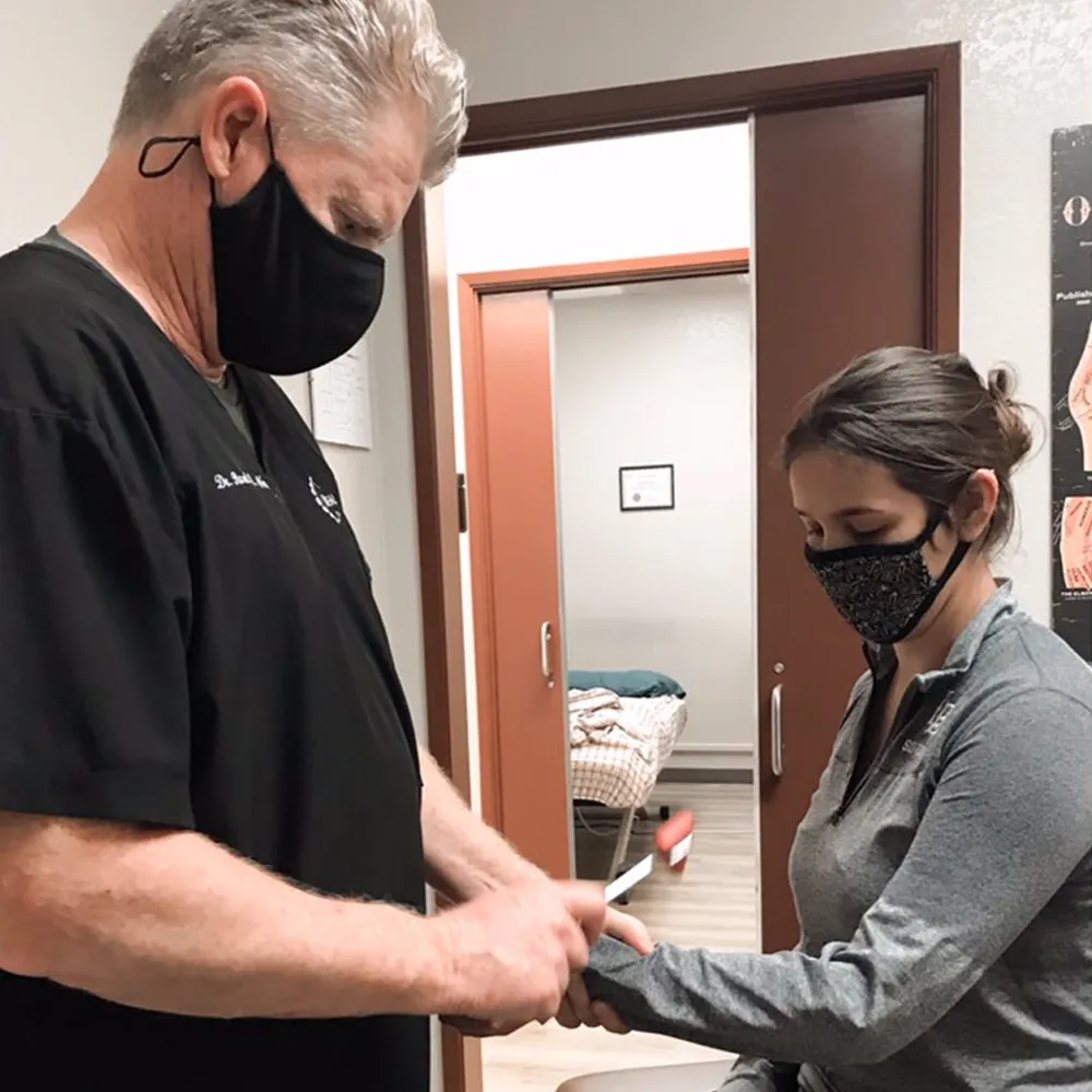 Chiropractor testing reflexes on patient