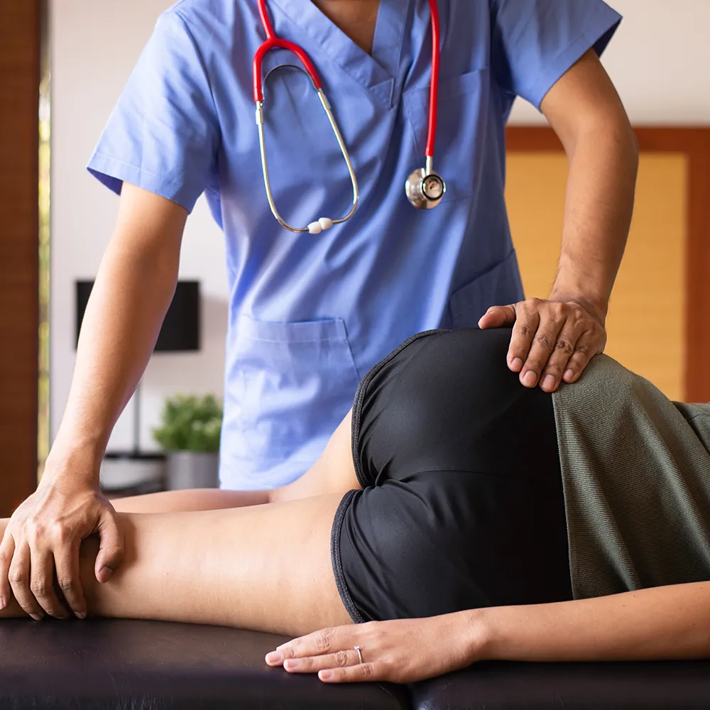 A chiropractor treats a patient's hip pain.