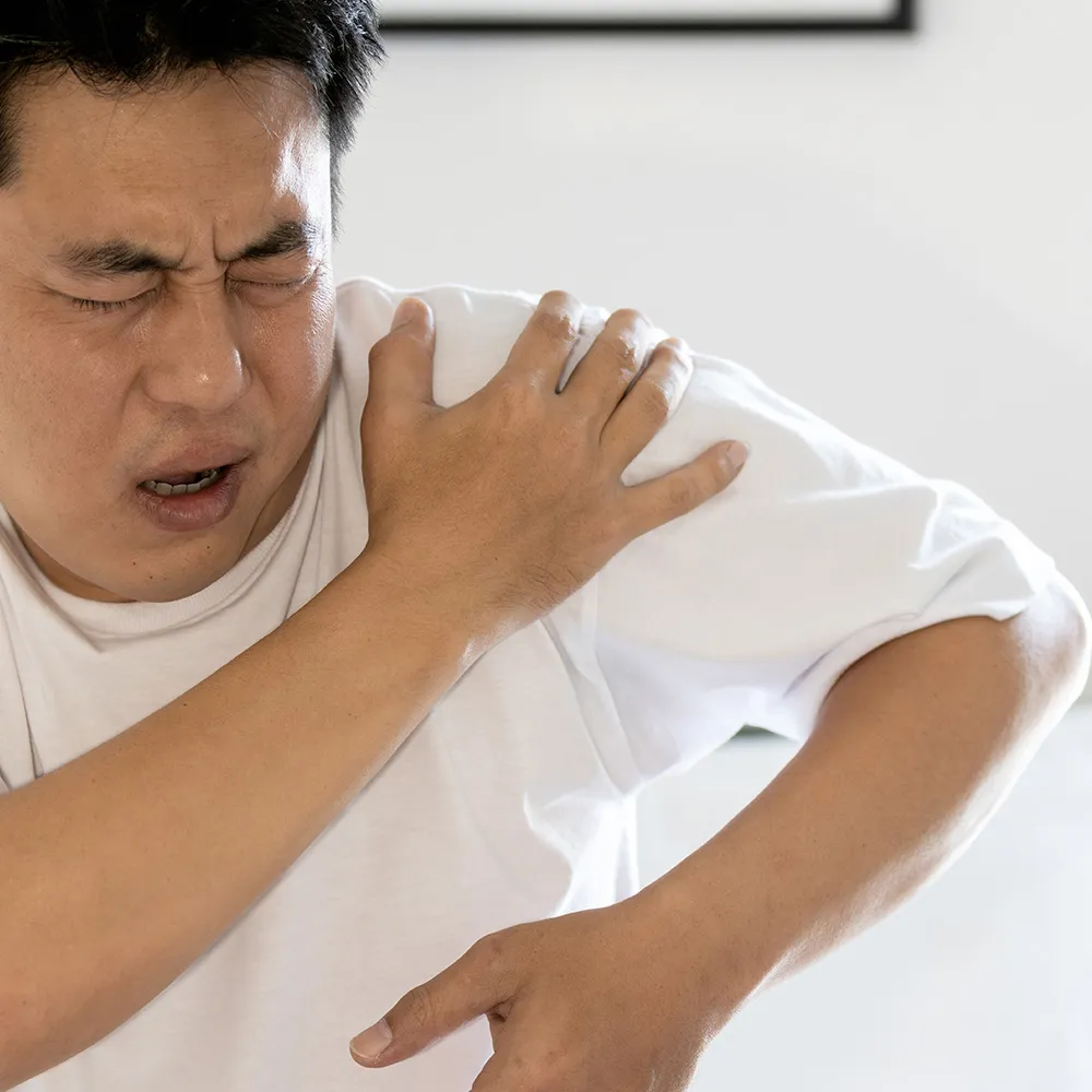 Man grimacing with painful shoulder.
