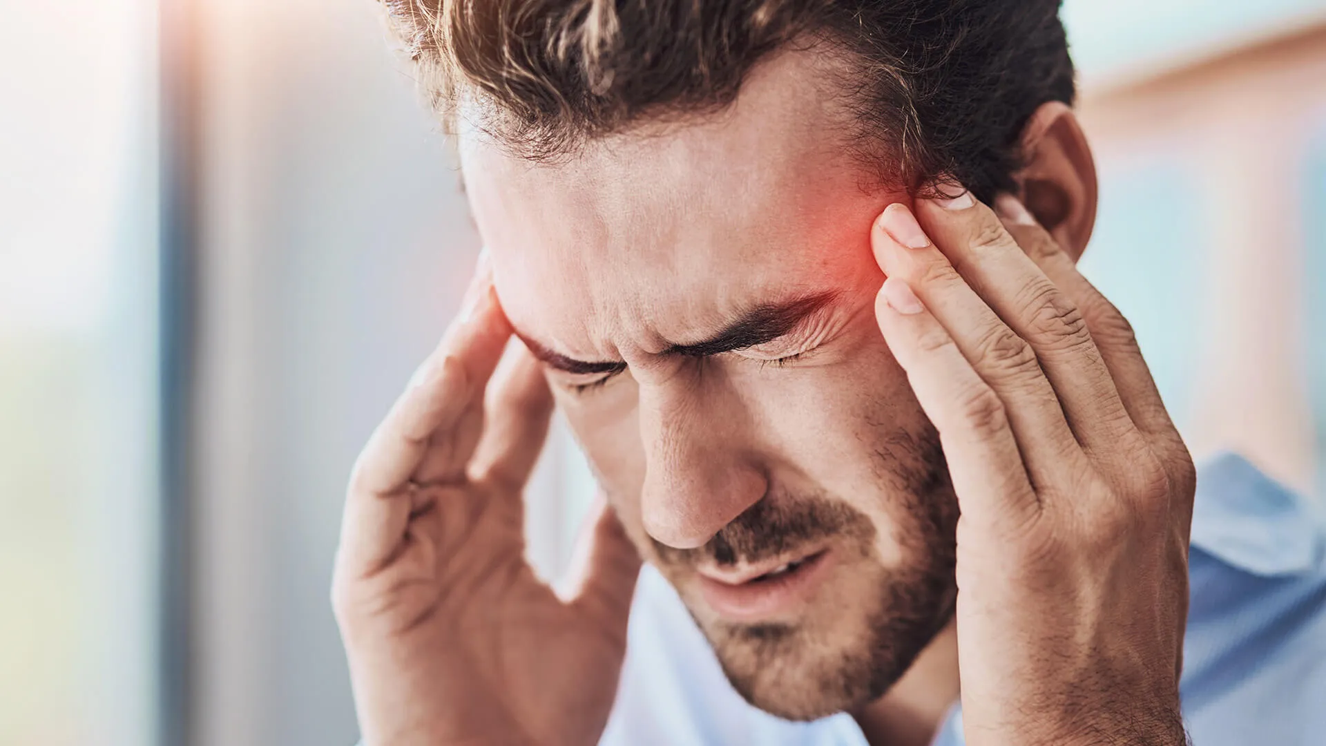 Man pressing temples with migraine pain
