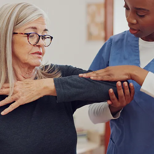 Chiropractor examining woman’s elbow.