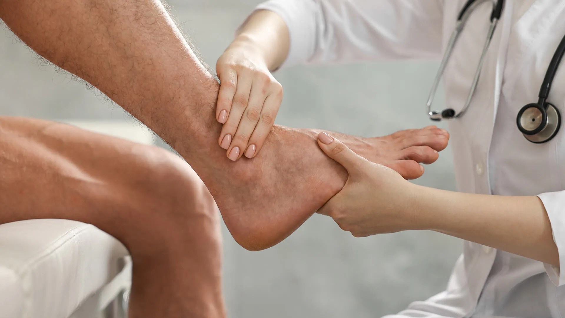 A doctor examining a patient's foot and ankle.