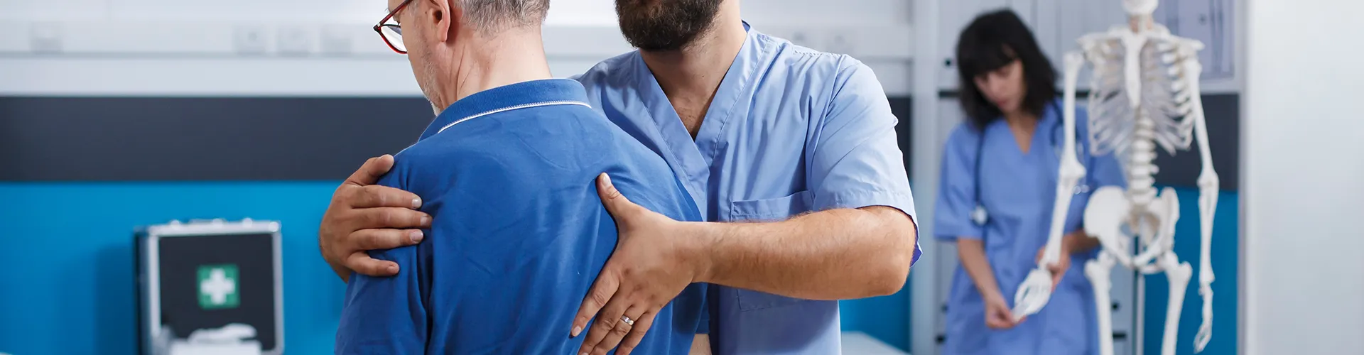 Chiropractor adjusting seated patient’s back.
