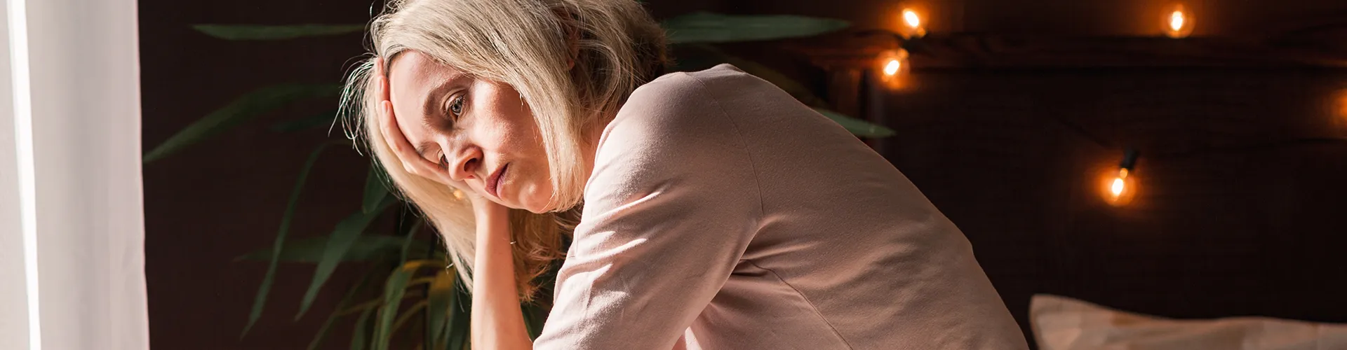 Tired woman holding her face with one hand.