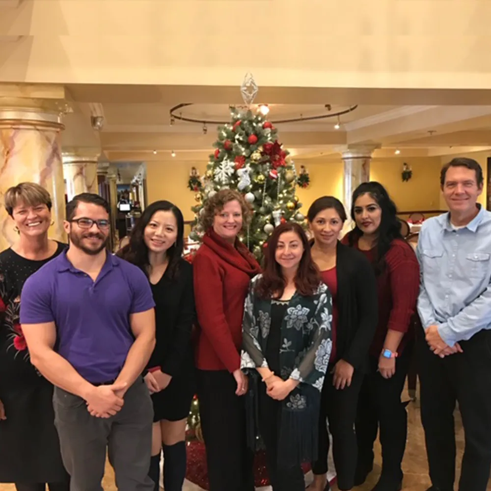 Chiropractic team group photo by Christmas tree.