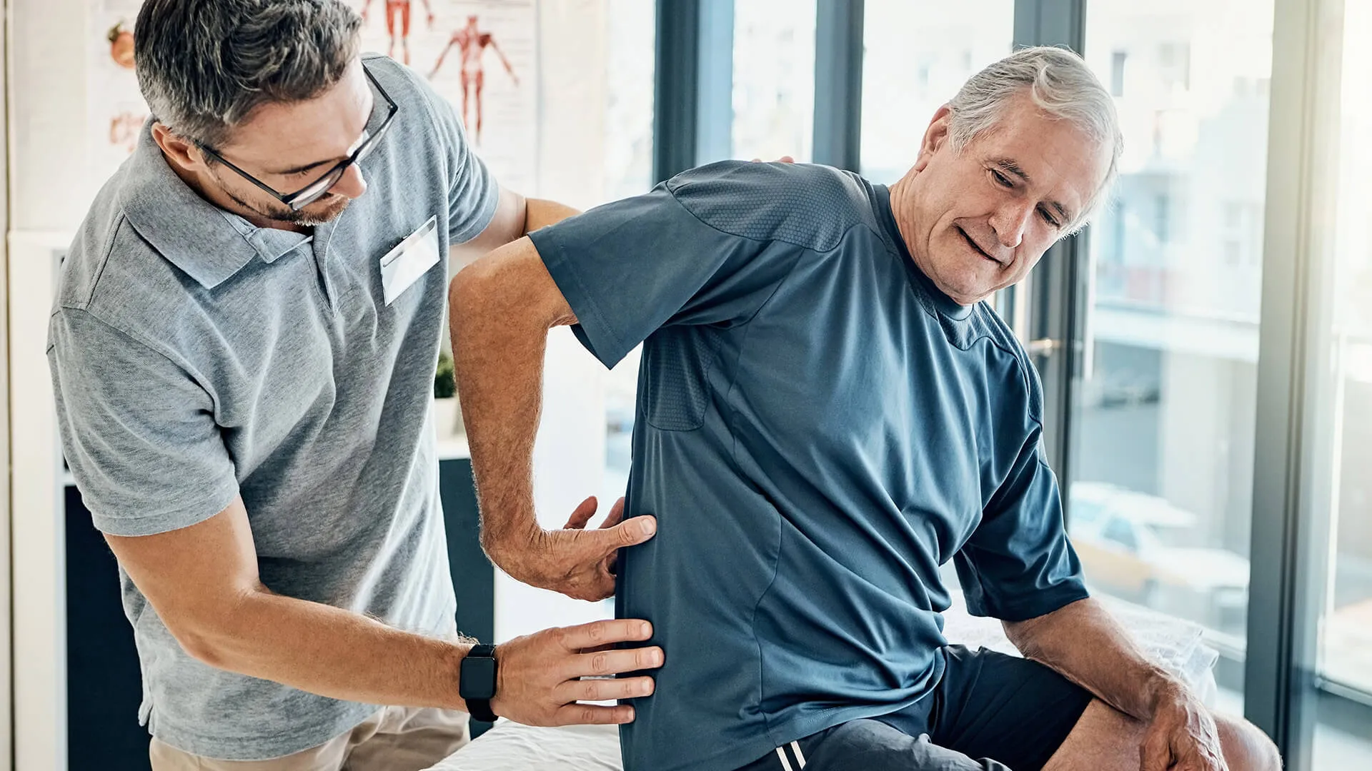 Chiropractor treating a senior man for back pain.