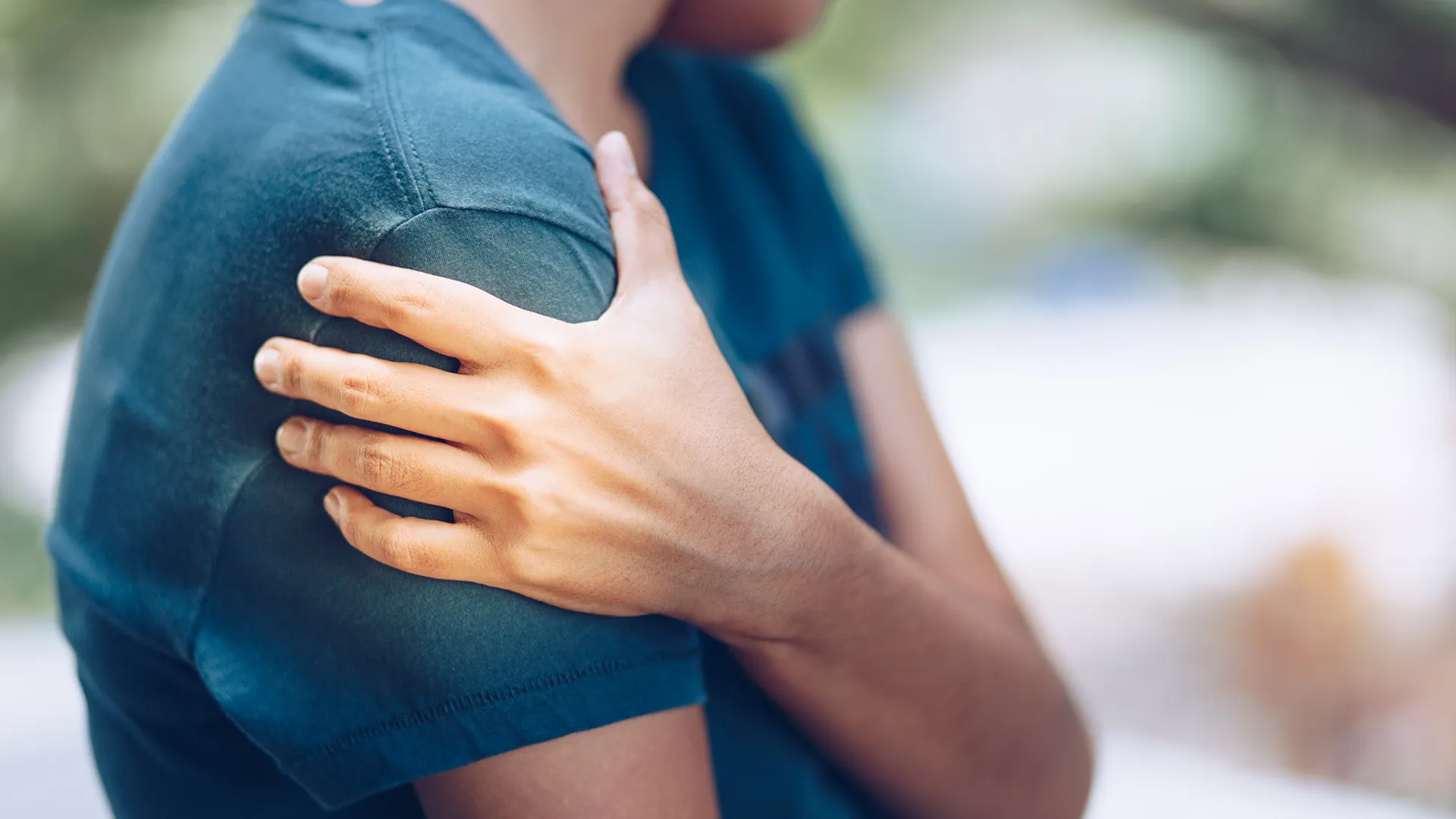 Person holding shoulder in visible pain.