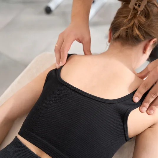 Woman lying face down receiving a back massage.