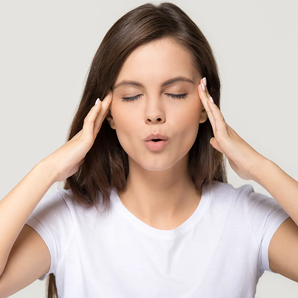Young woman massaging temples for migraine relief
