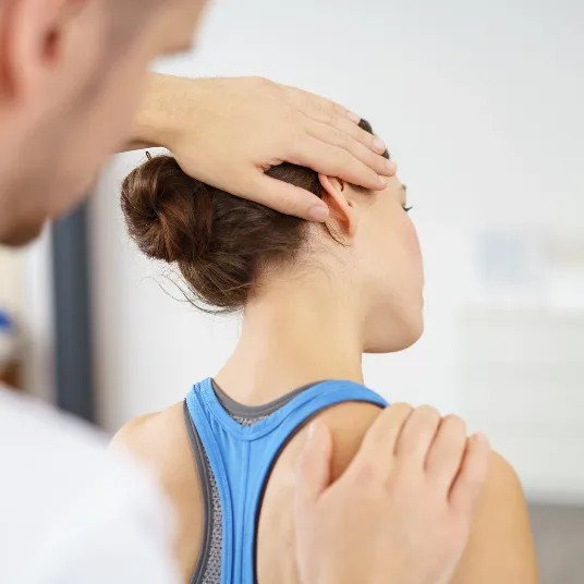 Chiropractor gently twisting patient’s neck during adjustment.