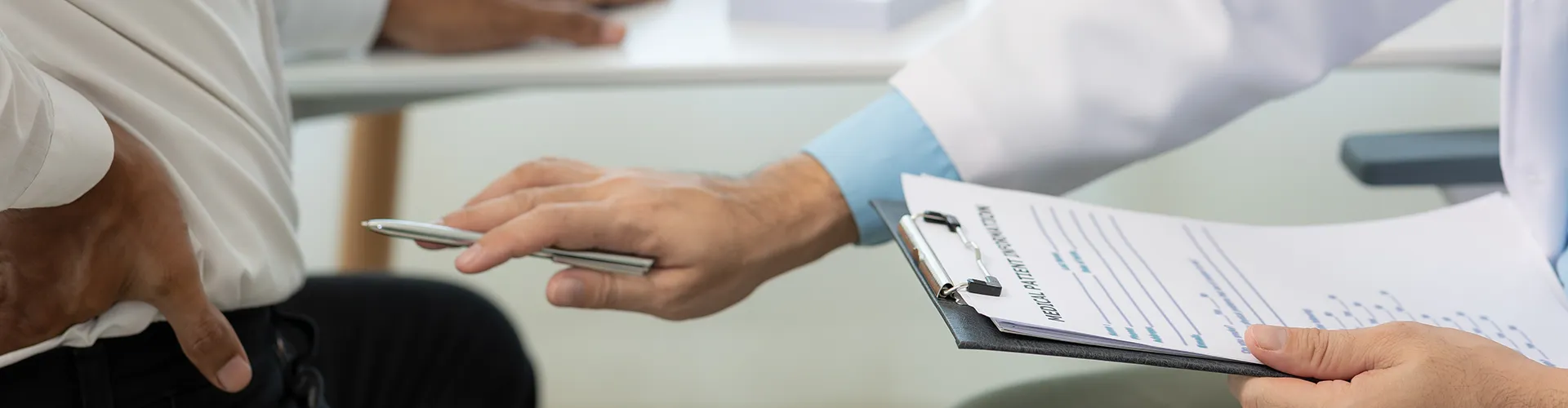 Chiropractor taking notes with pen about patient’s condition.
