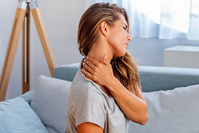 Woman massaging neck in pain  