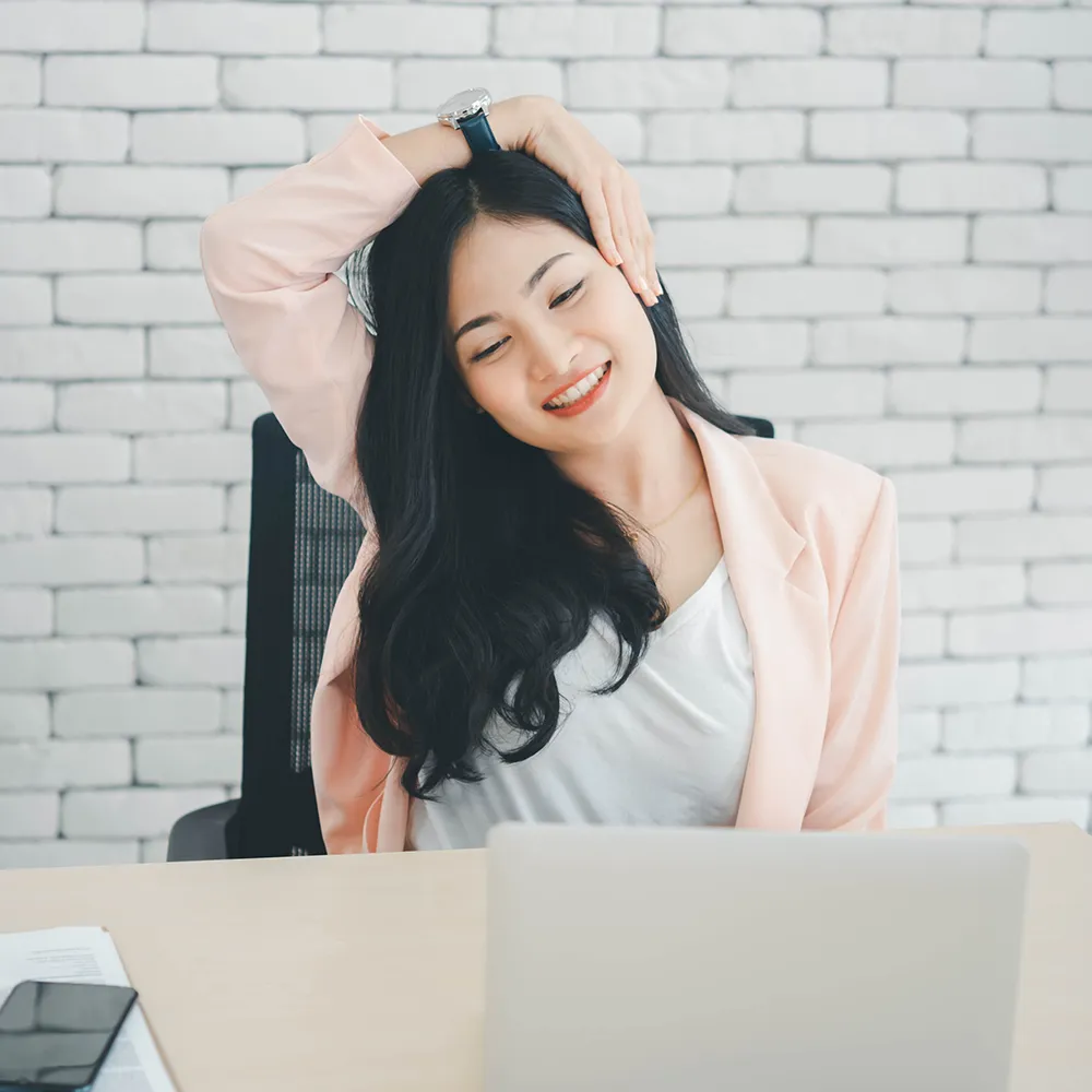 Woman stretching neck at office desk