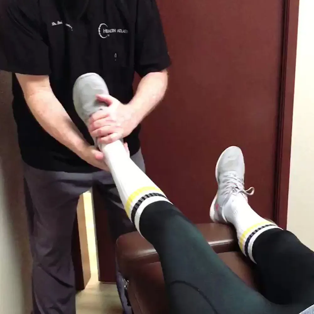 Chiropractor adjusting patient’s ankle joint