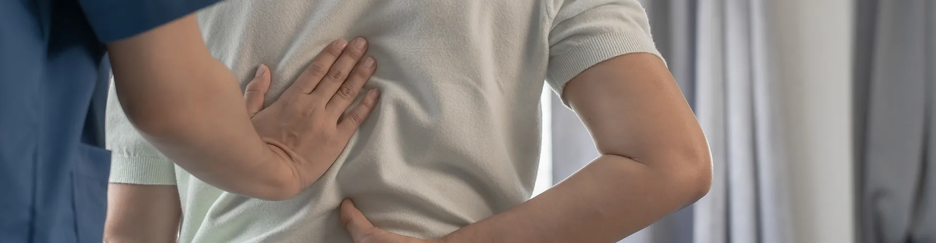 Chiropractor examining patient’s back.
