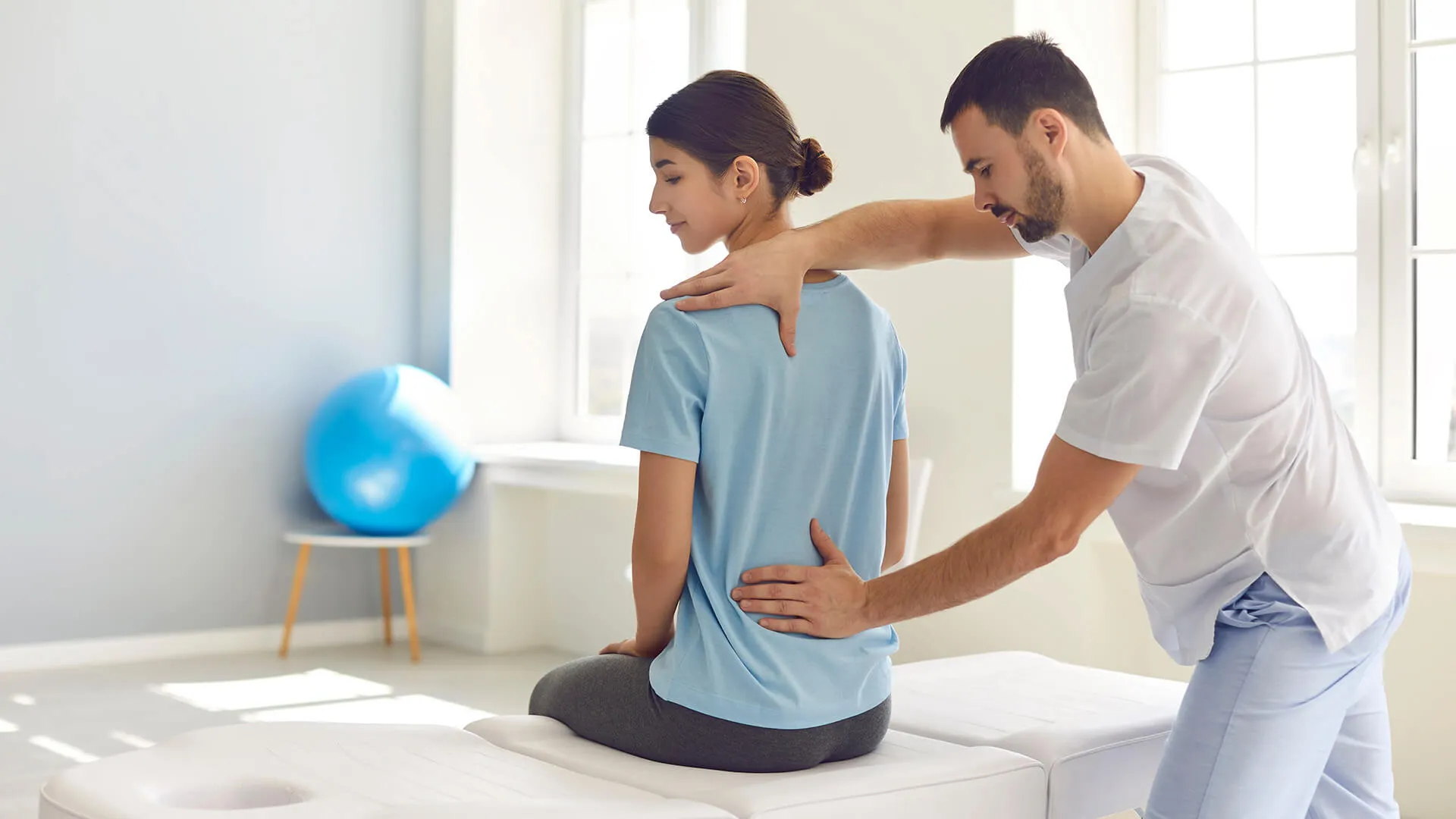 Man treating a woman with Scoliosis