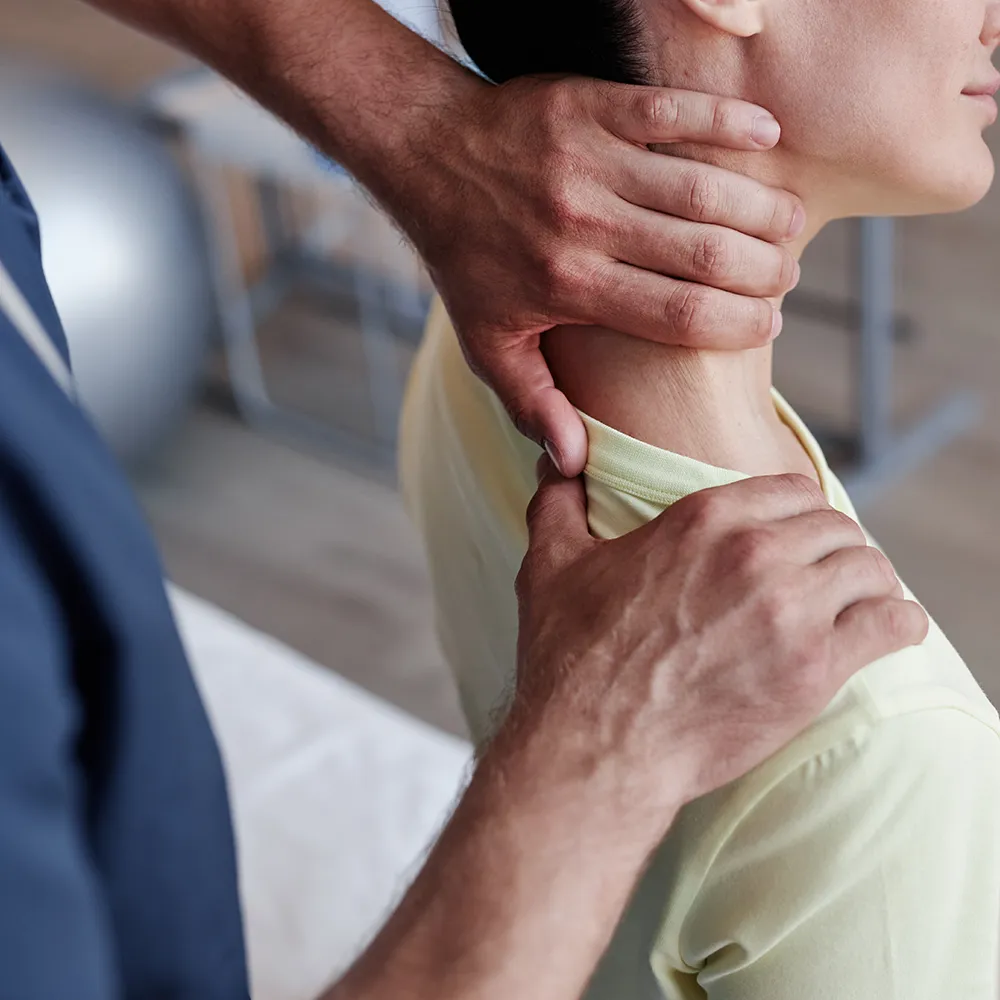 Chiropractor adjusting woman’s neck and shoulders