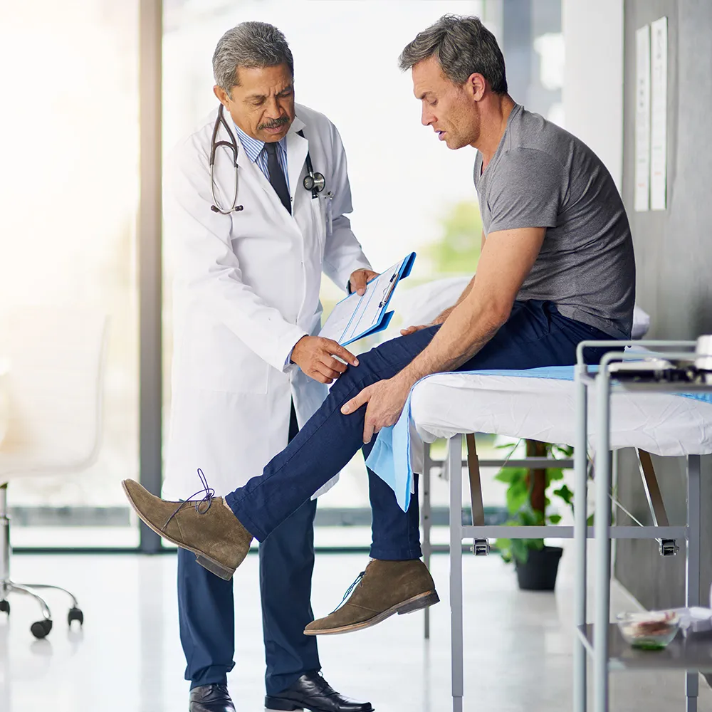 Doctor examining patient’s injured knee.