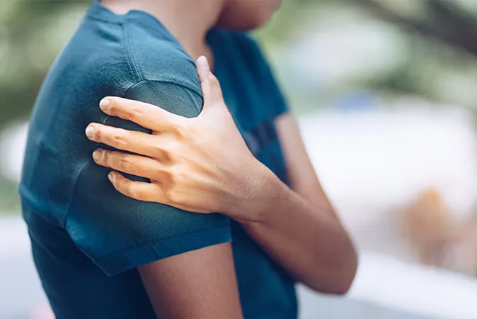 Woman touching shoulder due to discomfort