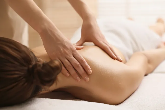Woman lying face down receiving a back massage.