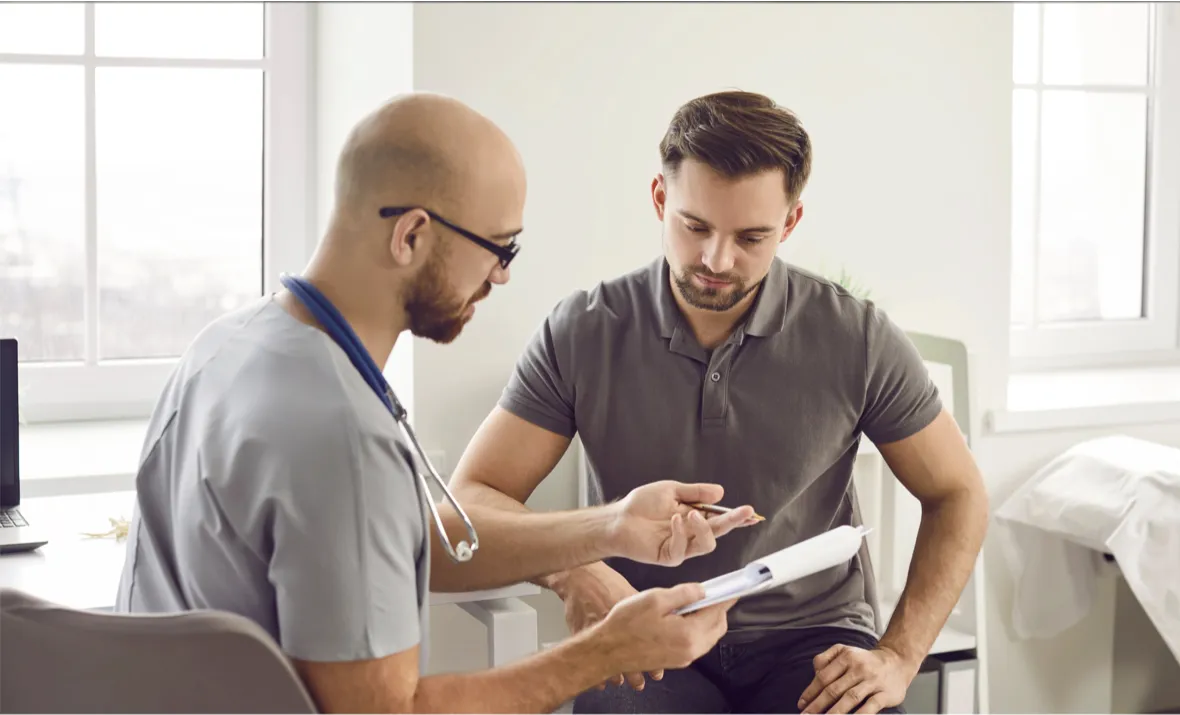 Chiropractor explaining treatment details with patient chart  