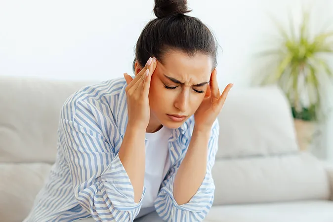 Woman pressing temples with headache  