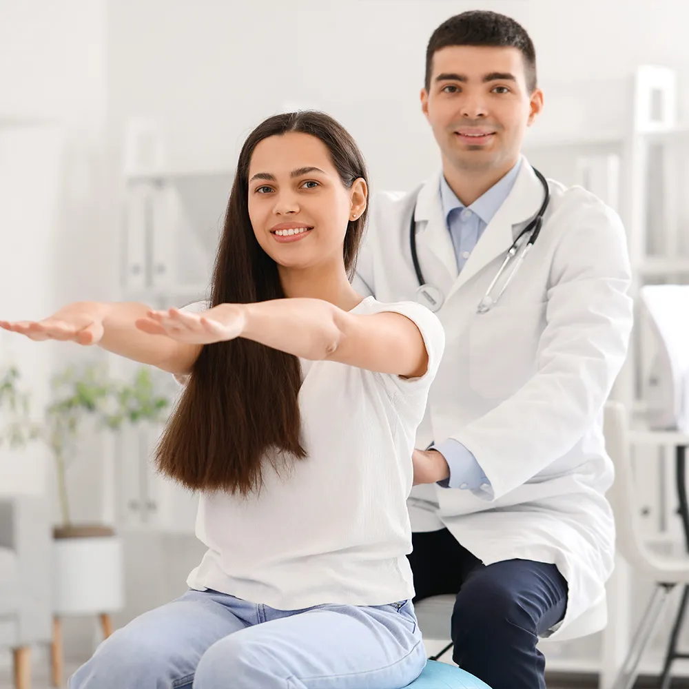 Doctor guiding scoliosis patient through posture test.