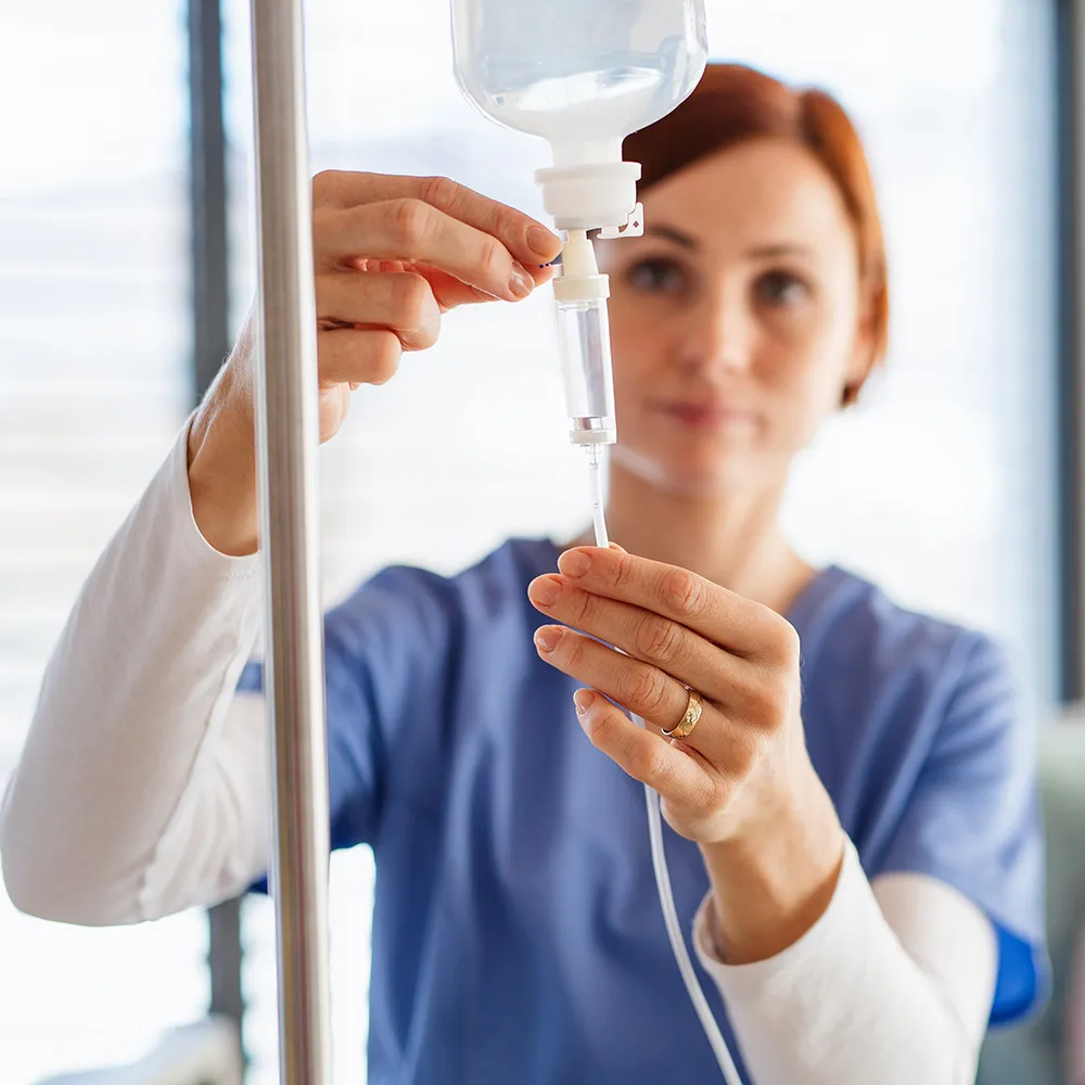 A nurse or medical professional preparing an IV drip.
