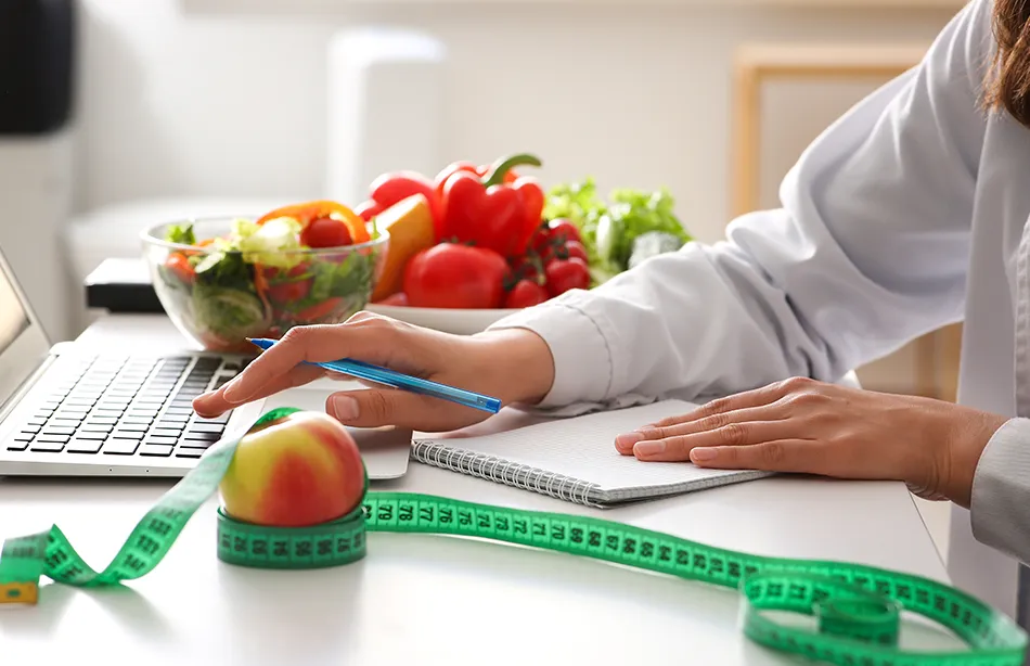 A nutritionist working on a healthy diet plan on her laptop.