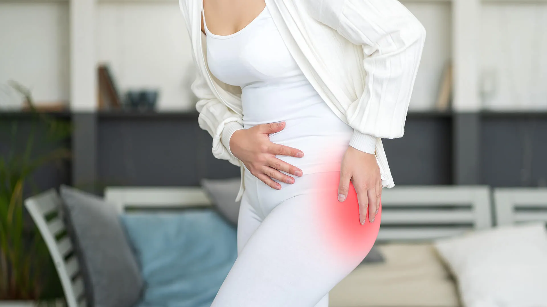 A woman holding her hip in pain.