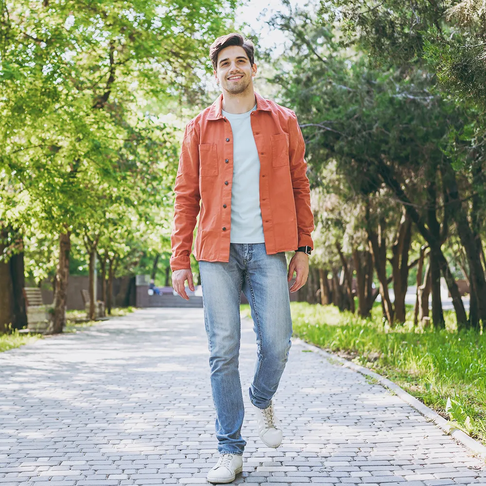 A happy man walking outdoors, representing mobility and wellness.