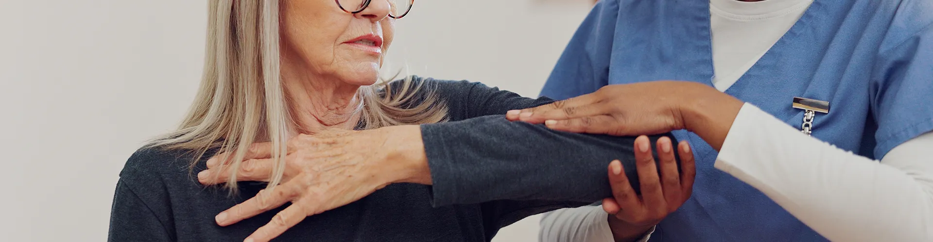 Chiropractor examining woman’s elbow.
