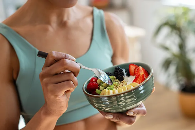 Woman eating fresh fruit plate 