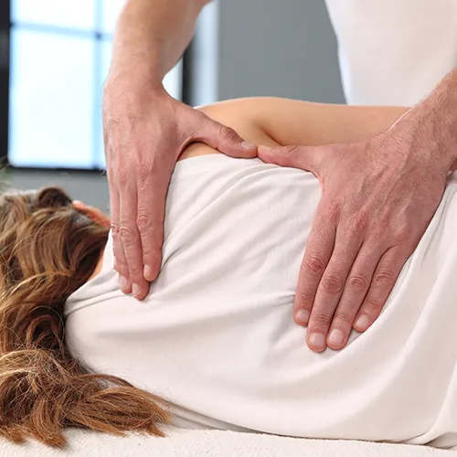 Chiropractor adjusting patient’s back.