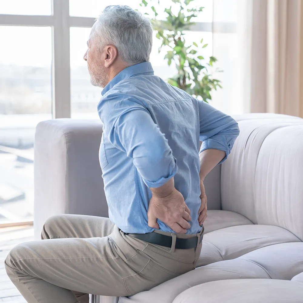 Senior man with back pain from herniated disc injuries.
