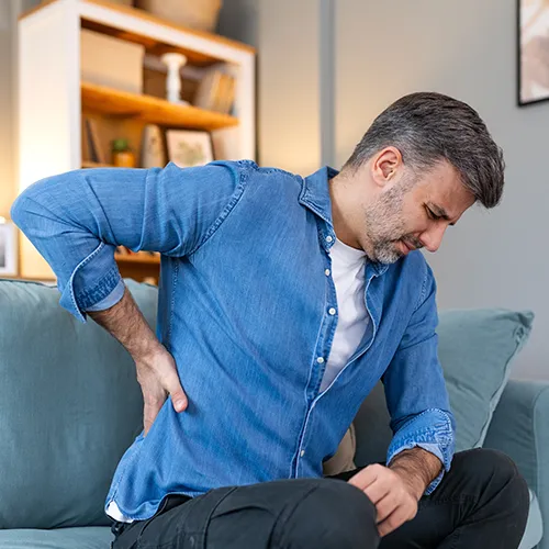 Man holding his back, showing signs of discomfort.
