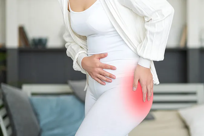 Woman touching hip in pain  