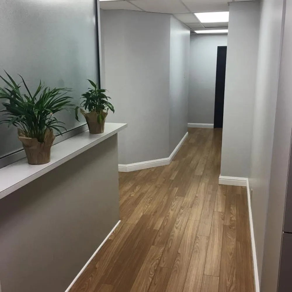 Clinic hallway with plants and wood floor