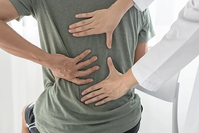 Man consulting doctor for severe back pain
