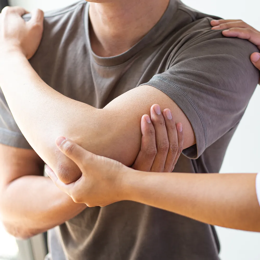 Chiropractor stretching patient’s arm during therapy
